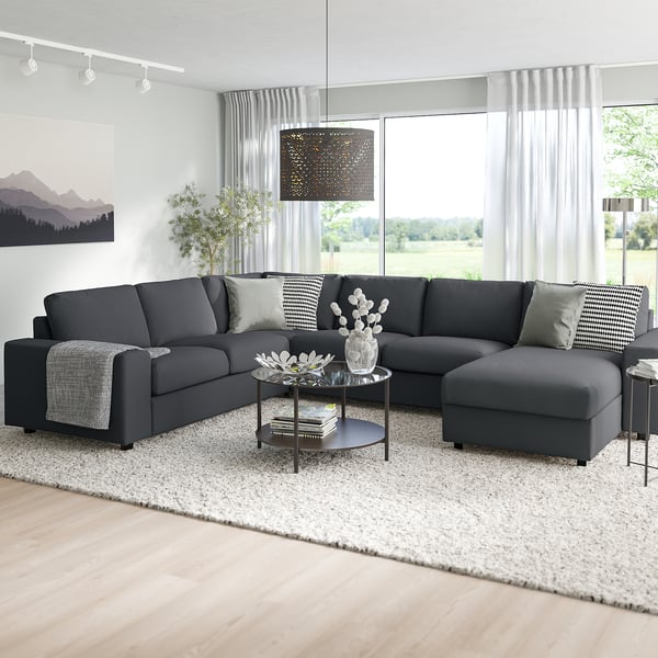 Modern living room with grey VIMLE sectional, chrome coffee table, and large windows.
