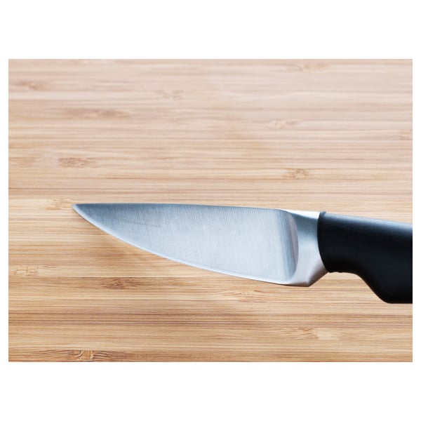 Sharp paring knife on wooden cutting board, showcasing quality blade and comfortable grip.
