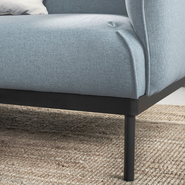Modernes hellblaues Sofa, schlanke Metallbeine, weiche Kissen.