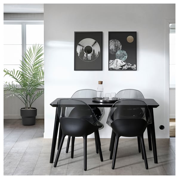 Moderner Essbereich mit 4 schwarzen Stühlen, abstrakter Wandkunst, minimalistischem Dekor, Pflanze.