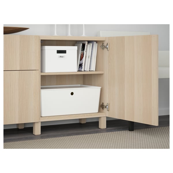 Heller Holzschrank mit offenen Türen, die den Aufbewahrungskasten, die Bücher und die Schublade zeigen.