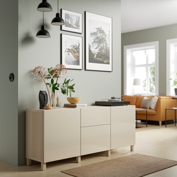 Hellbeiges IKEA BESTÅ Sideboard an grüner Wand, mit Trockenblumenvase und Schale darauf.