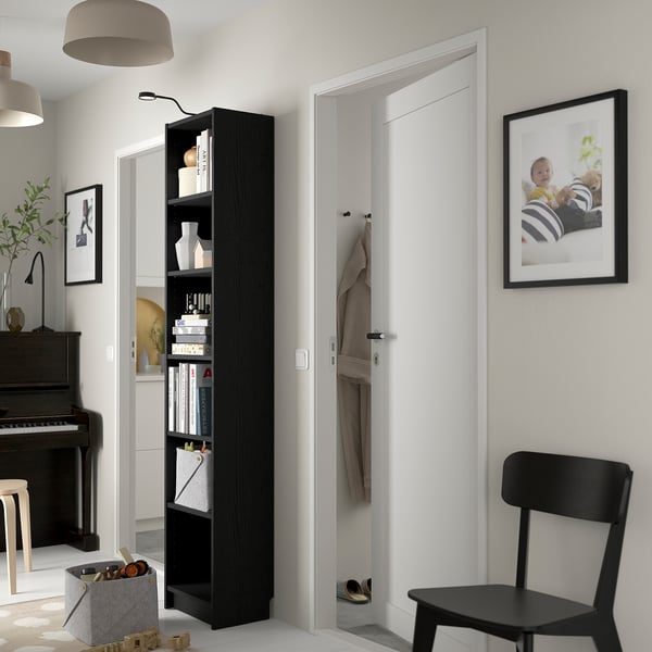 Modernes Wohnzimmer mit BILLY Bücherregal, Stuhl, Klavier und Dekor.