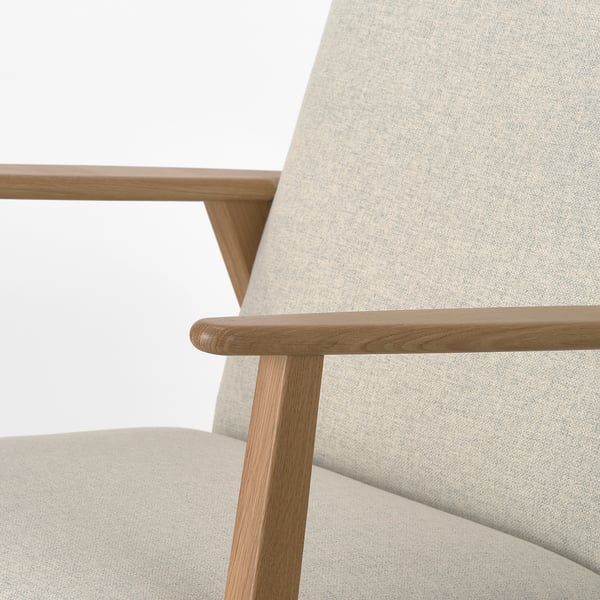 Stilvoller Retro-Sessel mit Massivholzbeinen und hellbeiger Polsterung, der das skandinavische Design der 1950er Jahre zeigt.
