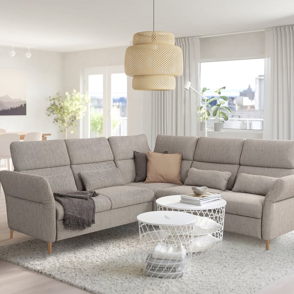 Modernes Wohnzimmer: großes graues FAMMARP-Sofa, weißer Couchtisch, runder Lampenschirm, große Fenster, Blick auf die Stadt.