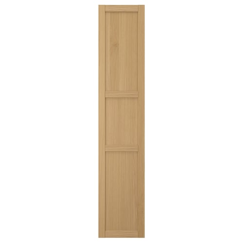 Eine FORSBACKA Küchenschranktür aus warmem Eichenfurnier. Es handelt sich um ein klassisches Rahmendesign mit abgeschrägten Kanten und natürlicher Holzoptik.