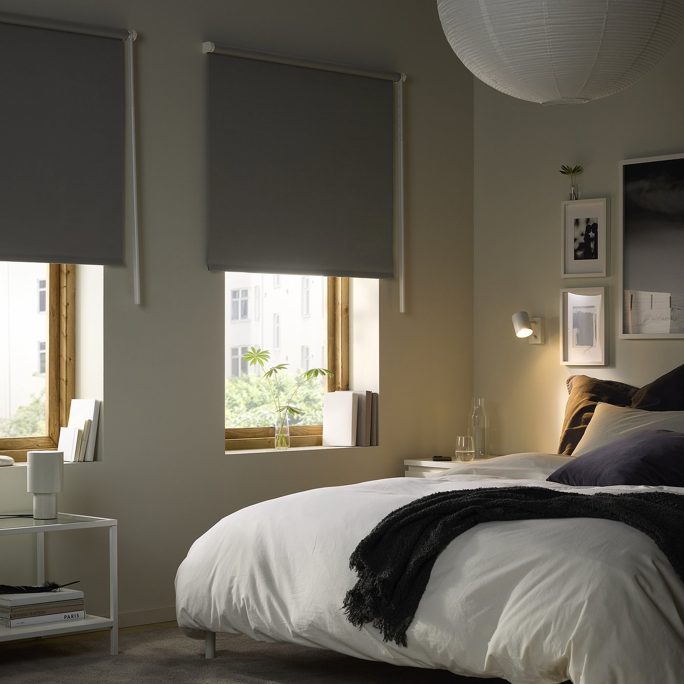 Modernes Schlafzimmer mit FRIDANS Jalousien, Bett, Nachttischen und Wandkunst.