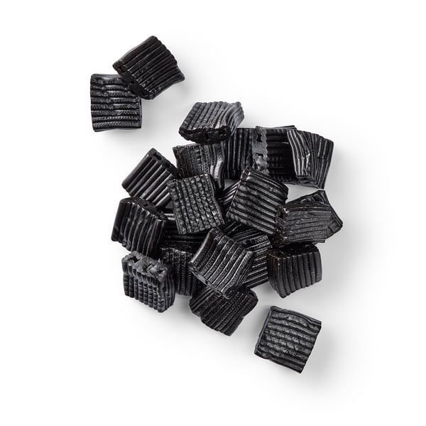 Schwarze rechteckige Bonbons mit gerippter Textur, wahrscheinlich aus natürlich aromatisiertem, zuckerhaltigem Lakritz.
