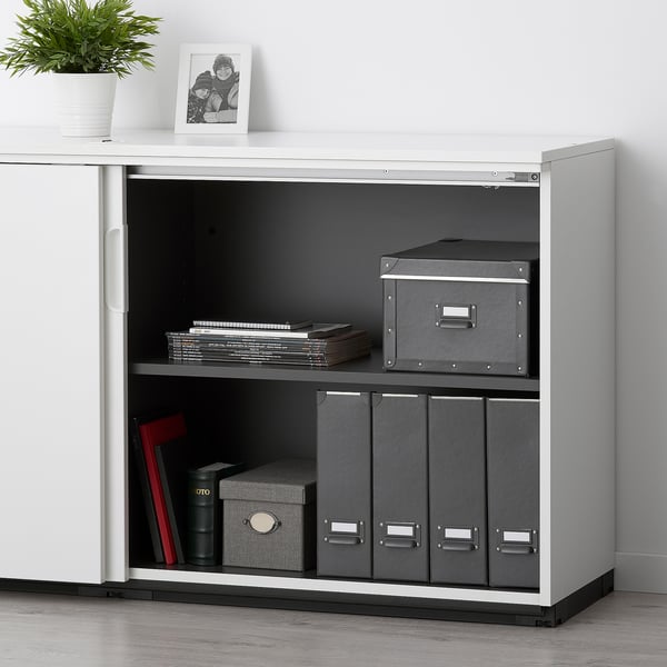Weißer GALANT-Schrank mit 2 Regalen, Combo-Schloss, grauen Boxen, Akten, Pflanze, Foto.