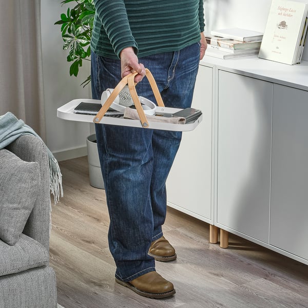 Person hält GRÖNFISK Tablett mit Gegenständen und präsentiert die Tragegriffe und die Mehrzweckfunktionalität.