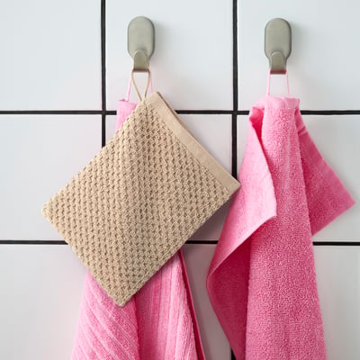 GULVIAL: Baumwollbeige und rosa Handschuhe hängen groß an Haken.