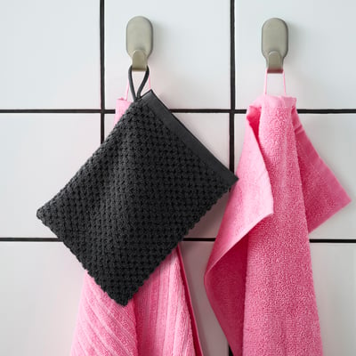 Hänge zwei GULVIAL-Handschuhe auf: rosa und grau, weiche Baumwolle, quadratisch, mit Schlaufen, an Gitterwandhaken. Rosa, eine größer.
