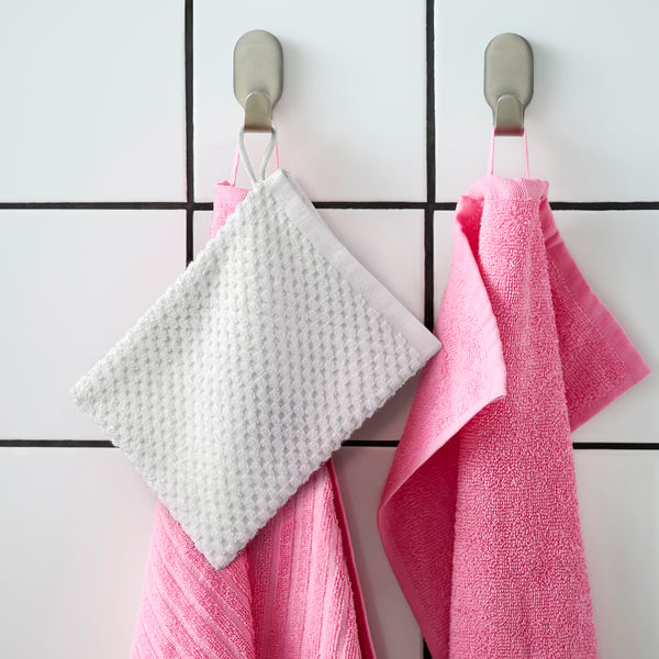 Zwei GULVIAL-Handschuhe hängen; eine weiße, eine rosa an Metallhaken; Weiche Baumwolle, quadratische Form.