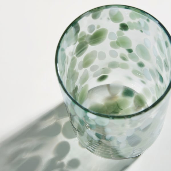 Glasvase mit grünen und weißen Punkten, die das Licht reflektieren. Gut verarbeitet, mit einer glatten, klaren Textur.