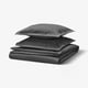 Dunkelgraues HAMPFLOCKEL-Bettset mit knackigem Baumwoll-Percale, mit geometrischen Formen und verdeckten Knöpfen für einen eleganten Stil.