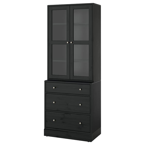 HAVSTA: hoher schwarzer Holzschrank mit Glastüren und drei Schubladen im rustikalen Design.