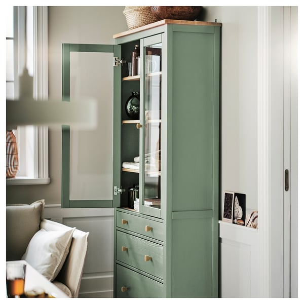 Grüner HEMNES-Glastürschrank mit Dämpfern, verstellbaren Einlegeböden und Dekor.