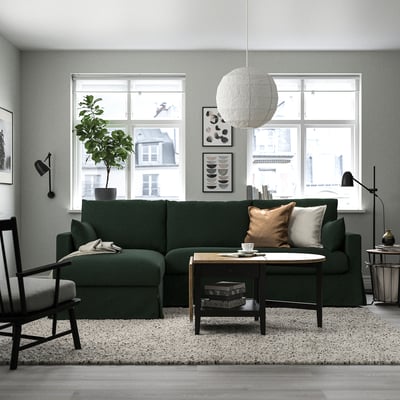 Grünes Sektionssofa HYLTARP im gemütlichen Wohnzimmer. Modernes Design mit Kissen, Couchtisch und großem Fensterblick.