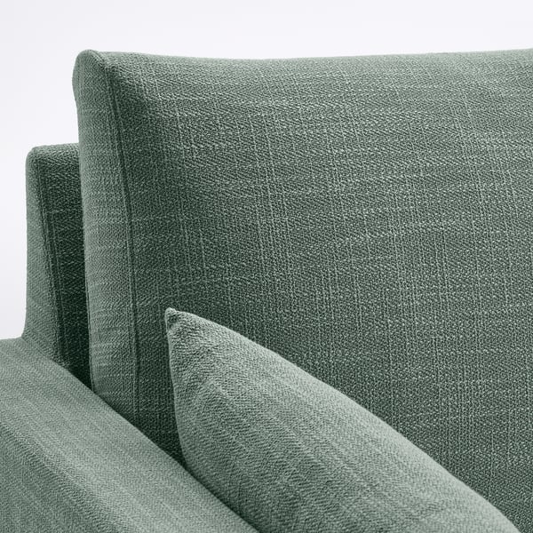 Bequemes Sofa mit dickem, strukturiertem grünem Stoff. Rücken- und Sitzkissen sehen weich und stützend aus und sind zum Entspannen konzipiert.