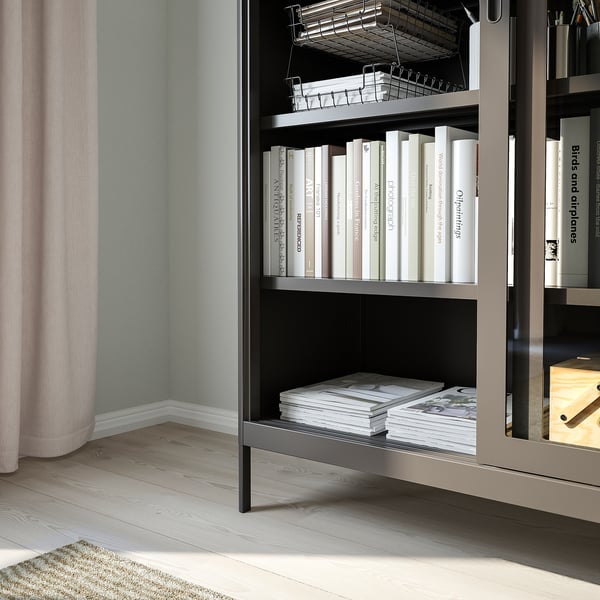 Bücherregal mit Glasschiebetüren, die Staub fernhalten. Das Design aus gehärtetem Glas und Metall bietet Langlebigkeit und ein luftiges Gefühl.
