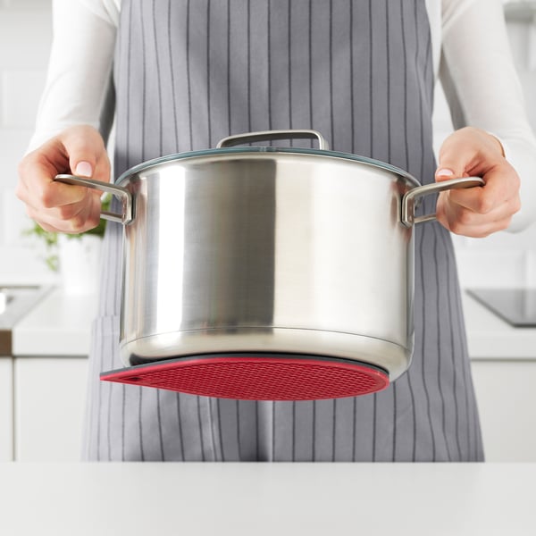 Person, die auf rotem Induktionsherd kocht