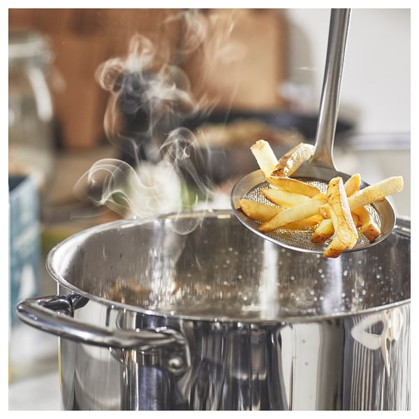 Stellen Sie sich eine silberne Pfanne mit aufsteigendem Dampf und einem Löffel frittiertem Essen vor.