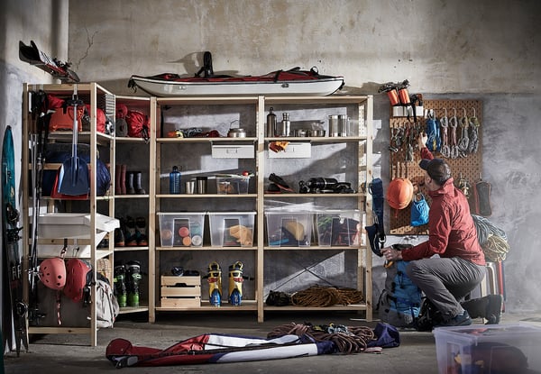 Person, die Outdoor-Ausrüstung im Raum mit IVAR-Stauraum und Pegboard organisiert.