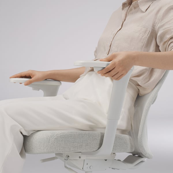 Person, die die Lendenwirbelstütze des ergonomischen Bürostuhls einstellt.