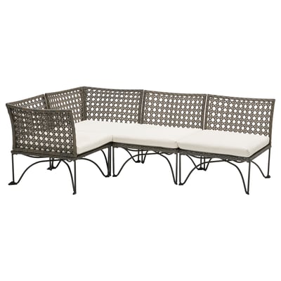 JUTHOLMEN Outdoor-Sofa aus schwarzem Korbgeflecht und weißen Kissen, angeordnet in modularer L-Form mit einem stilvollen, komplizierten Webdesign.