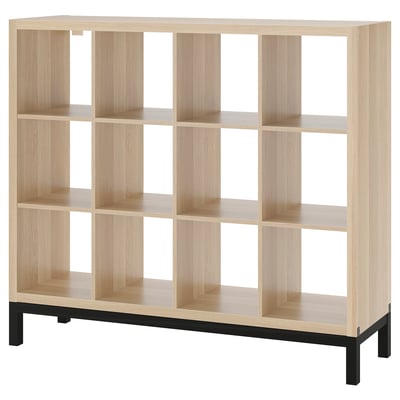 Ein hellbraunes, würfelförmiges Regal von ikea KALLAX mit Metallsockel, das eine moderne und organisierte Aufbewahrungslösung bietet.