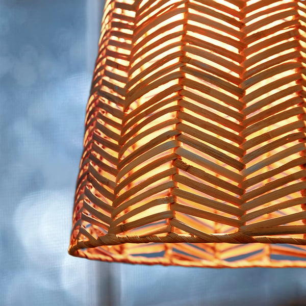 Handgefertigter Lampenschirm mit kompliziertem Fischgrät-Rattan-Muster, das warmes, einladendes Licht wirft.