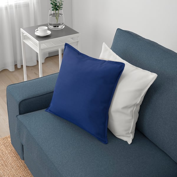 Blaues Sofa mit weißen Kissen; Gemütliches und einladendes Wohnzimmer.