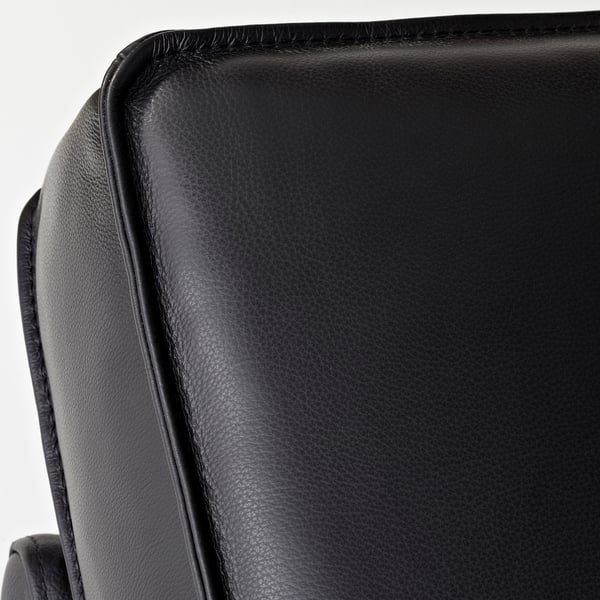 Nahaufnahme der glatten, schwarzen Lederoberfläche der KIVIK-Sofas, die die hochwertige Verarbeitung und die Nähte zeigt.