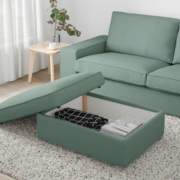 Modernes Wohnzimmer mit Salbei KIVIK Sofa, Ottomane mit Stauraum und Beistelltisch mit Pflanze.