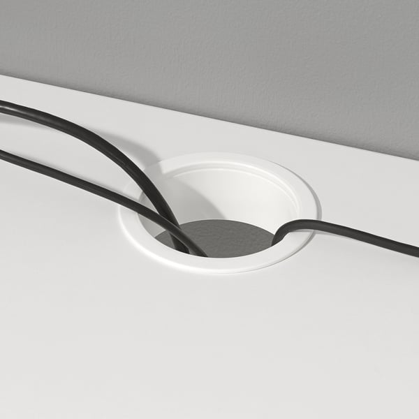Weißer Schreibtisch mit kreisförmigem Kabelauslass, der schwarze Kabel aufnimmt, um die Organisation und Zugänglichkeit zu erleichtern.