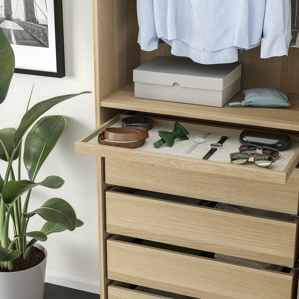 Kommode aus Holz mit ausziehbarer Schublade für Accessoires, Kleidung und eine Pflanze.
