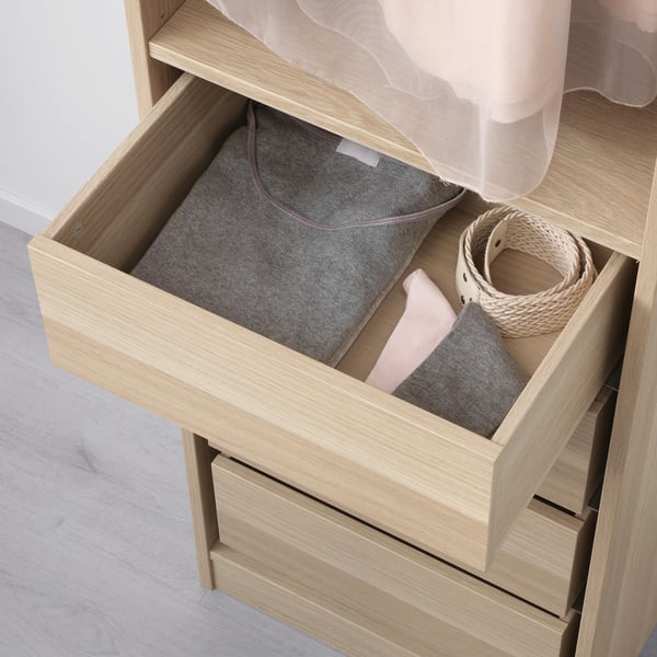 Offene Holzschublade mit Aufbewahrungsbox und Korb, Teil des IKEAS KOMPLEMENT Systems.