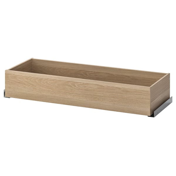 Eine leere Holzschublade aus der Serie KOMPLEMENT, ideal für die Organisation von Kleidung und Accessoires, mit einem schlanken, natürlichen Finish.