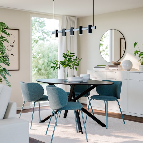 Türkisfarbene KRYLBO-Esstischstühle, Metallrahmen, Tisch, heller Teppich, Sideboard mit Pflanzen, Spiegel, große Fenster mit Vorhängen.
