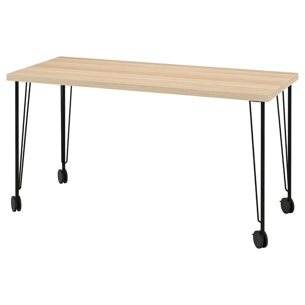 LAGKAPTEN: Schreibtisch aus hellem Holz mit Beinen und Rädern aus schwarzem Metall.
