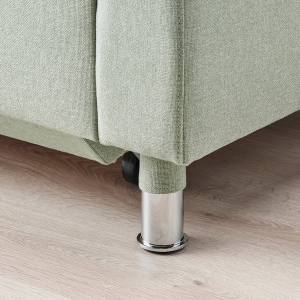 Moderne verchromte Beine tragen ein grün gepolstertes Sofa und zeigen ein robustes Design.