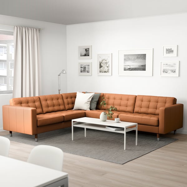 Modernes Wohnzimmer mit brauner Sektion, Couchtisch und abstrakter Kunst.