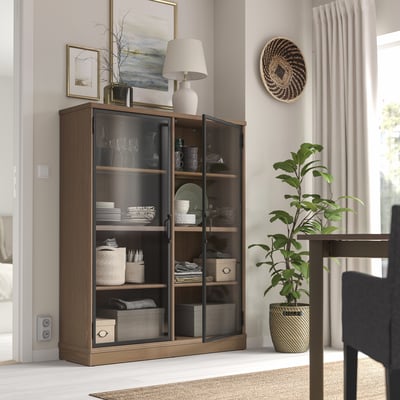 LANESUND Schrank mit Glastüren, Lampe und Dekor in geräumigem Raum