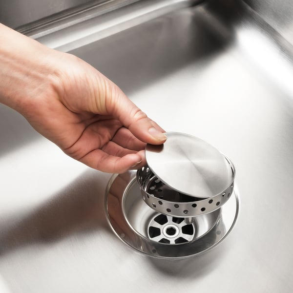 Platzieren Sie den magnetischen Waschbeckendeckel von Hand auf das LILLVIKEN-Sieb, wodurch eine ebene Oberfläche entsteht.