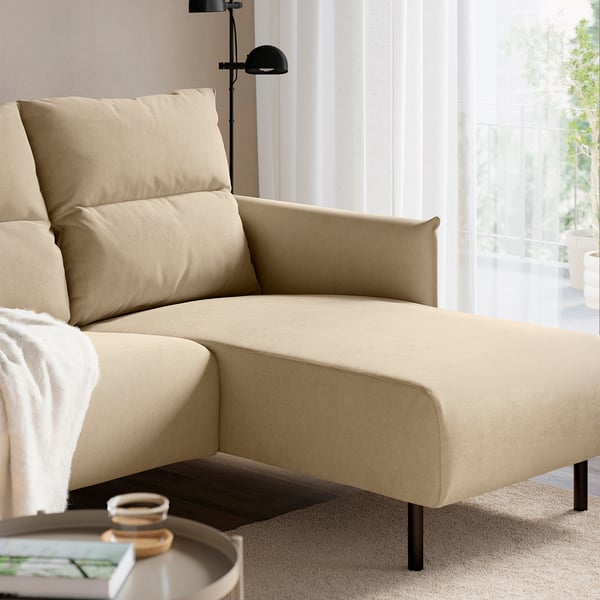 Modernes beiges Sofa mit hoher Rückenlehne und Chaiselongue für Komfort, in der Nähe eines Fensters mit einer schwarzen Stehlampe daneben.