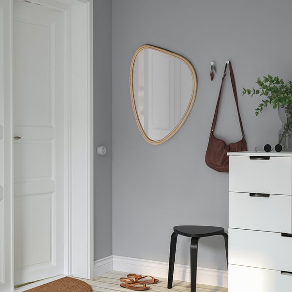MARISTOVA Spiegel an grauer Wand, größer als Hocker und Tasche. Tür, Kommode sichtbar.