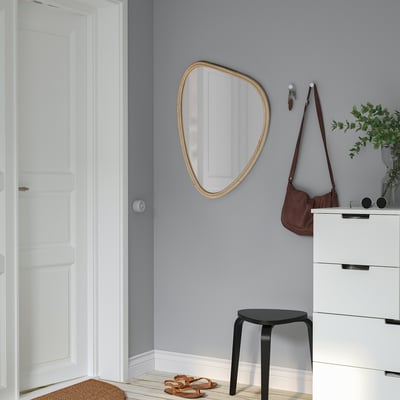 MARISTOVA Spiegel an grauer Wand, größer als Hocker und Tasche. Tür, Kommode sichtbar.