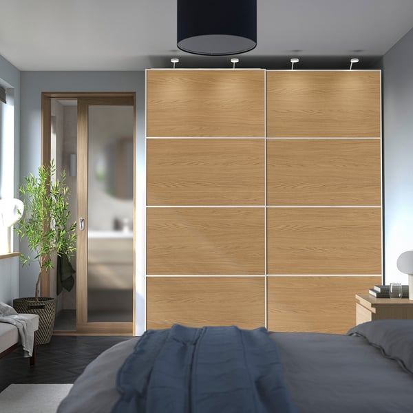 Der Schiebekleiderschrank erstreckt sich über den Raum, nahe der Decke. Modern, minimalistisch mit weich verschließenden Türen.