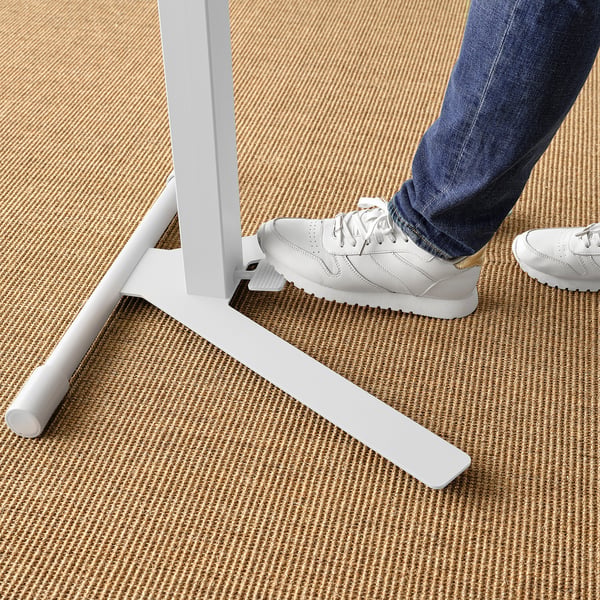 Person, die einen MITTZON-Laptopständer benutzt; Passt sich mit dem Fuß an, robustes Design auf gewebtem Teppich.