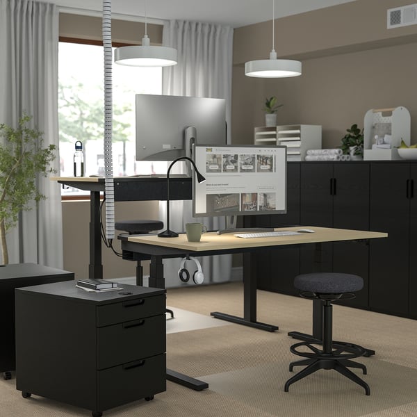 Modernes Büro mit MITTZON Stehpult, Hocker, Stauraum, Pflanzen, Kopfhörer.